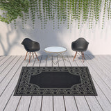 7' X 10' Black and Ivory Stain Resistant Indoor Outdoor Area Rug